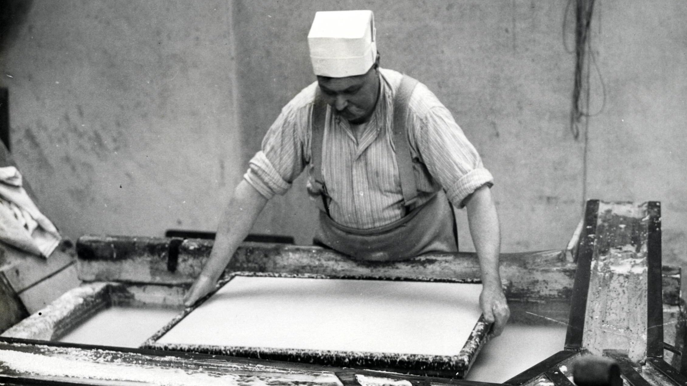 A vat man making paper in the mid-20th century.